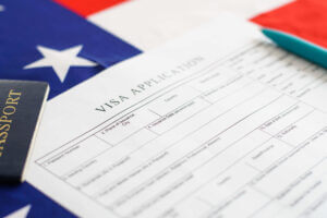 Extranjero rellenando una solicitud de inmigración tras aprender como solicitar visa de trabajo para USA