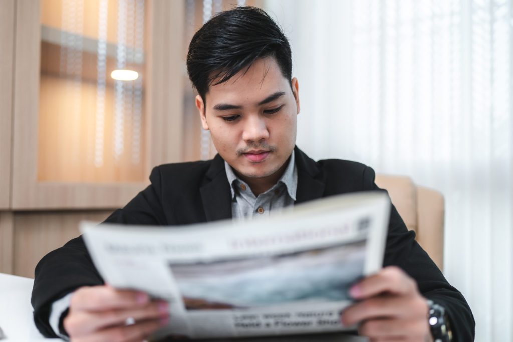 Hombre leyendo noticias, averiguando si tengo la visa u puedo aplicar para la residencia